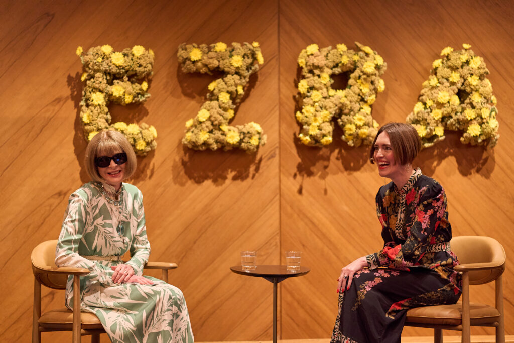 Anna Wintour and a fellow speaker share a light moment during an onstage conversation.