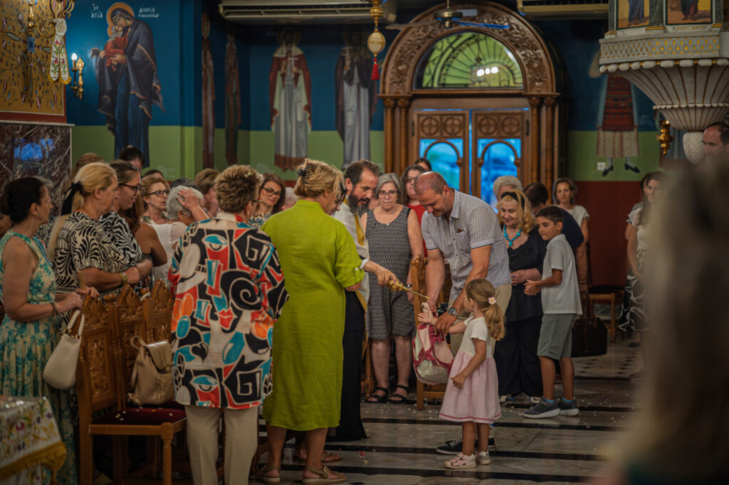 Priest blessing the parishioners with holy water as children and other worshippers participate