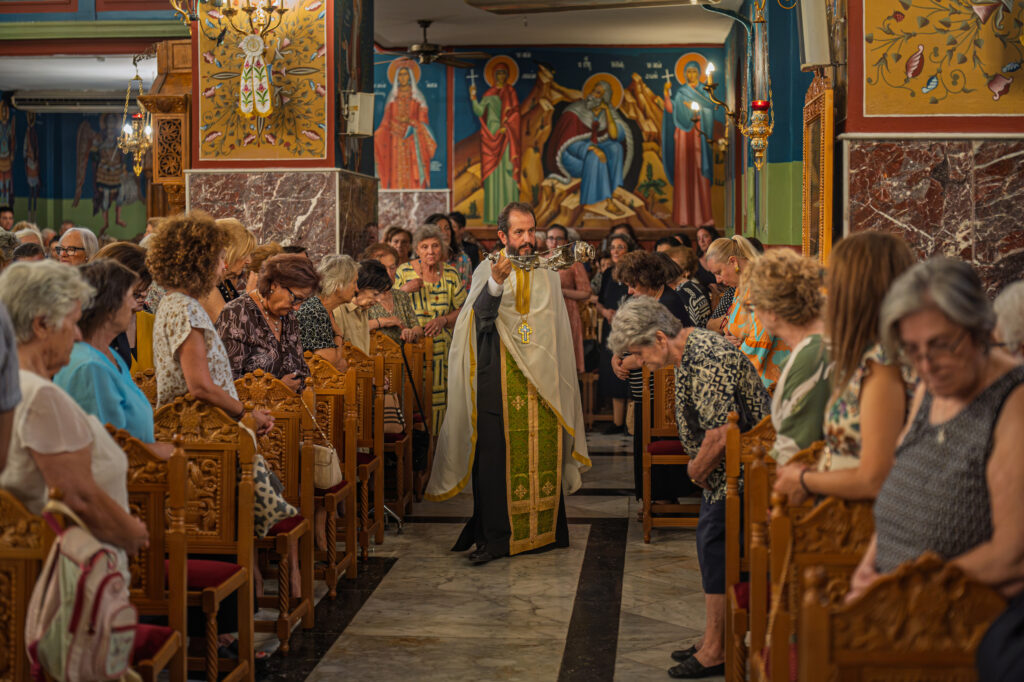 A priest incenses bowed worshippers in the central aisle.